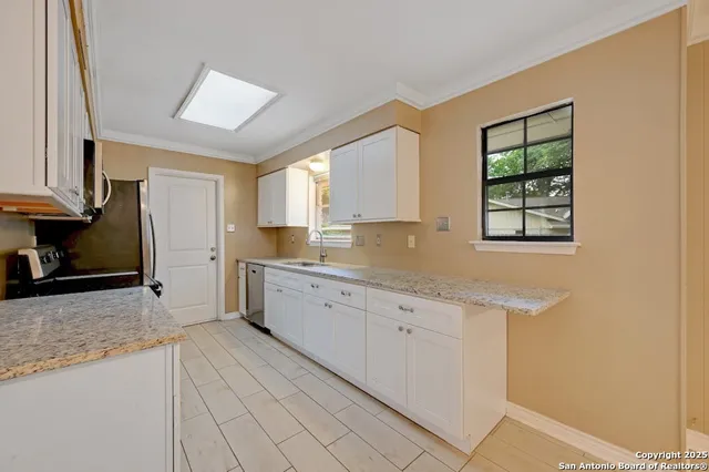 a kitchen with granite countertop cabinets a sink and a window