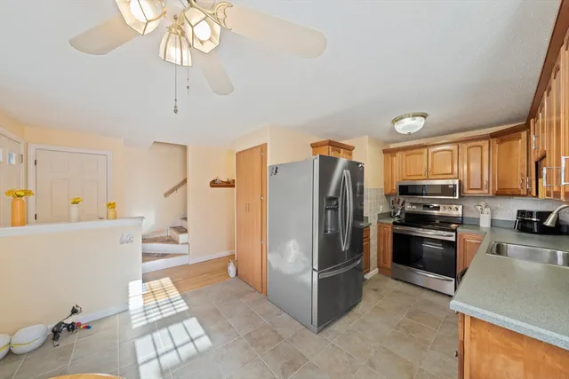 a kitchen with stainless steel appliances a refrigerator a stove a microwave and a dining table with wooden floor