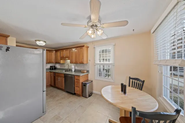 a kitchen with stainless steel appliances granite countertop a stove a sink dishwasher a dining table and chairs with wooden floor