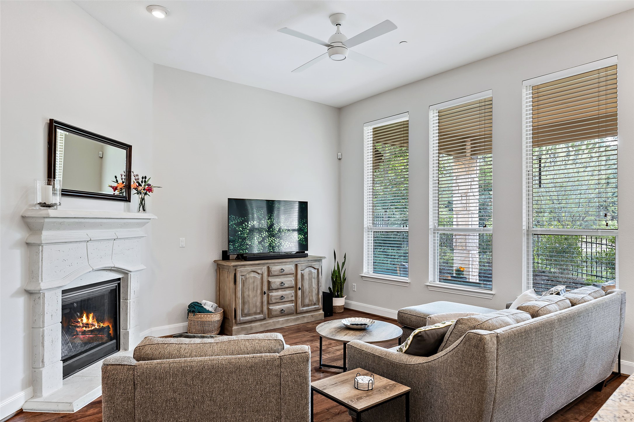 106 Maxwell Way Austin, TX 78738 - Photo 4 of 40 Living area featuring a fireplace, a ceiling fan, and wood finished floors