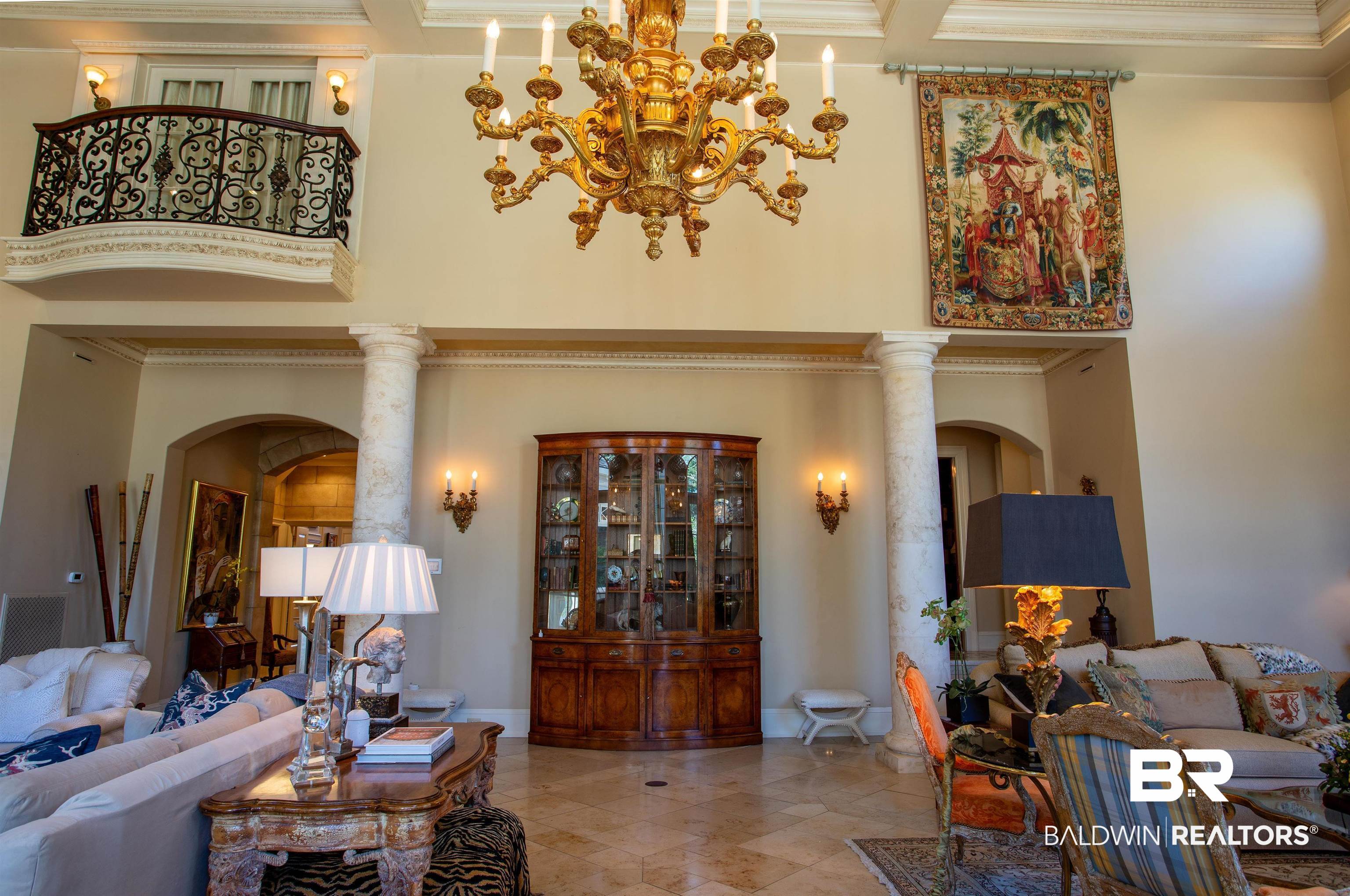 150 Austill Avenue Mobile, AL 36608 - Photo 12 of 39 Soaring ceiling with coffered detail, featuring a grand chandelier and an upper-level balcony with ornate ironwork