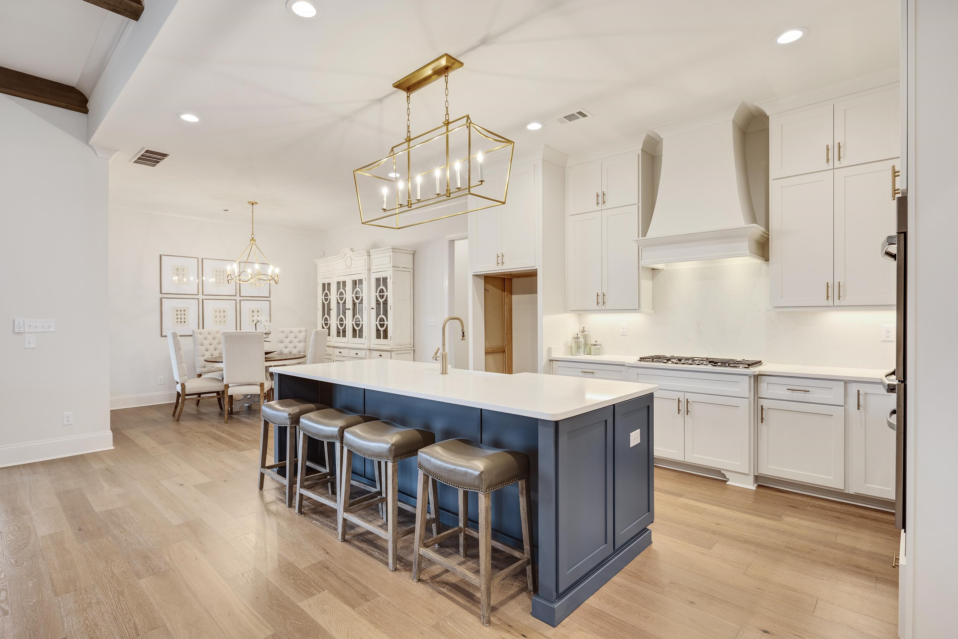 292 Keisie Lane Collierville, TN 38017 - Photo 11 of 40 Two tone kitchen featuring hanging lights, two tone cabinetry, a center island with sink, a breakfast bar area