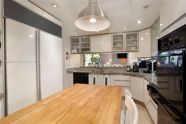 a kitchen with stainless steel appliances granite countertop a sink refrigerator stove and microwave