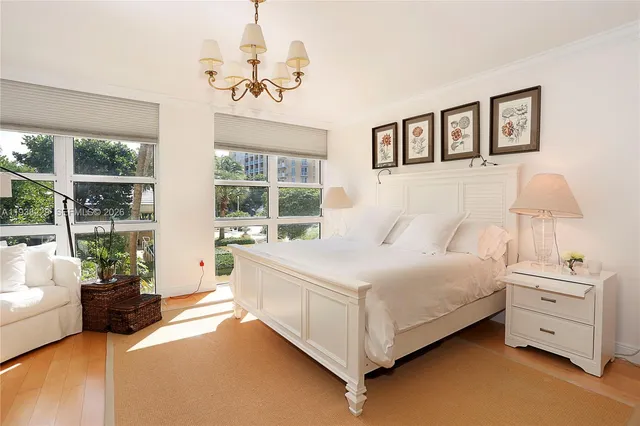 a bedroom with a large bed and a chandelier