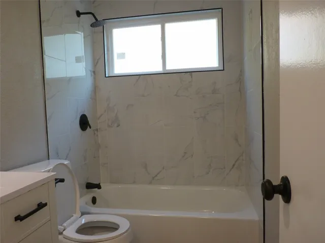 a bath room with a toilet and a bath tub