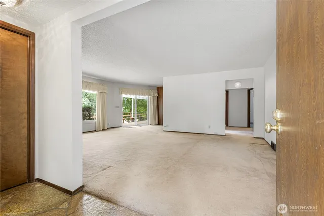 a view of a livingroom with an empty space and a window
