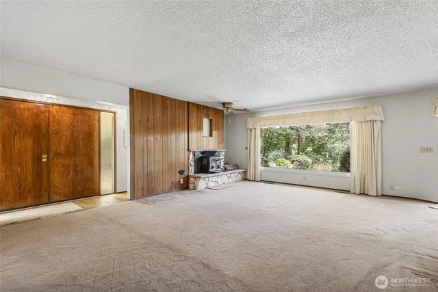 an empty room with fireplace and windows