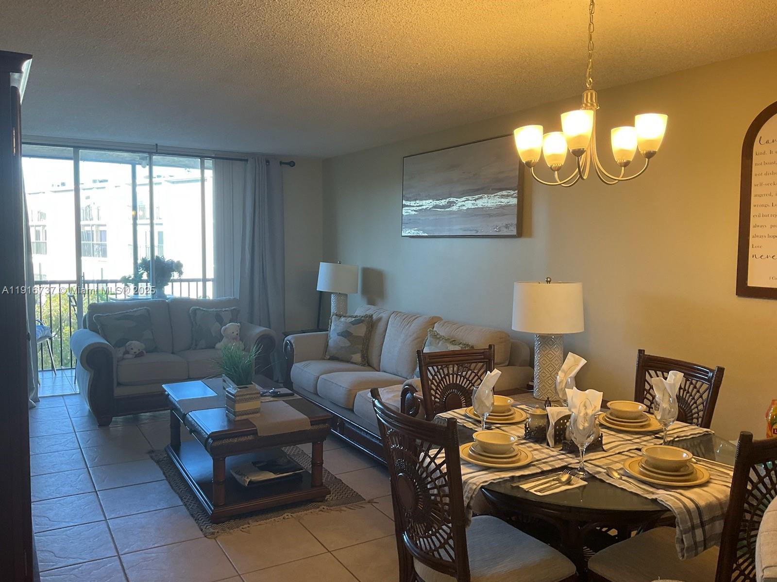 8730 Sherman Circle North, Unit 407 Miramar, FL 33025 - Photo 5 of 11 a living room with furniture a window and a chandelier