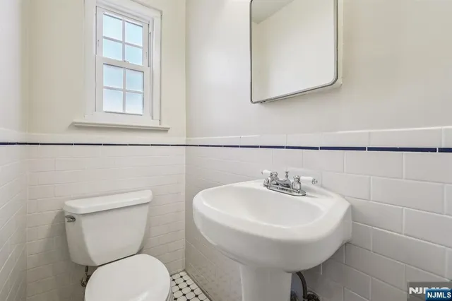 a bathroom with a toilet sink and mirror