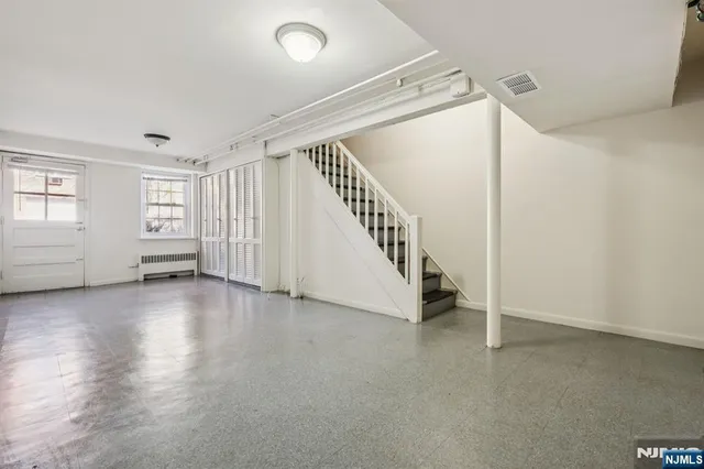 an empty room with windows and stairs