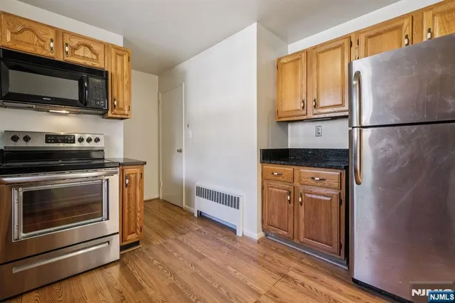 a kitchen with stainless steel appliances granite countertop a stove microwave and refrigerator