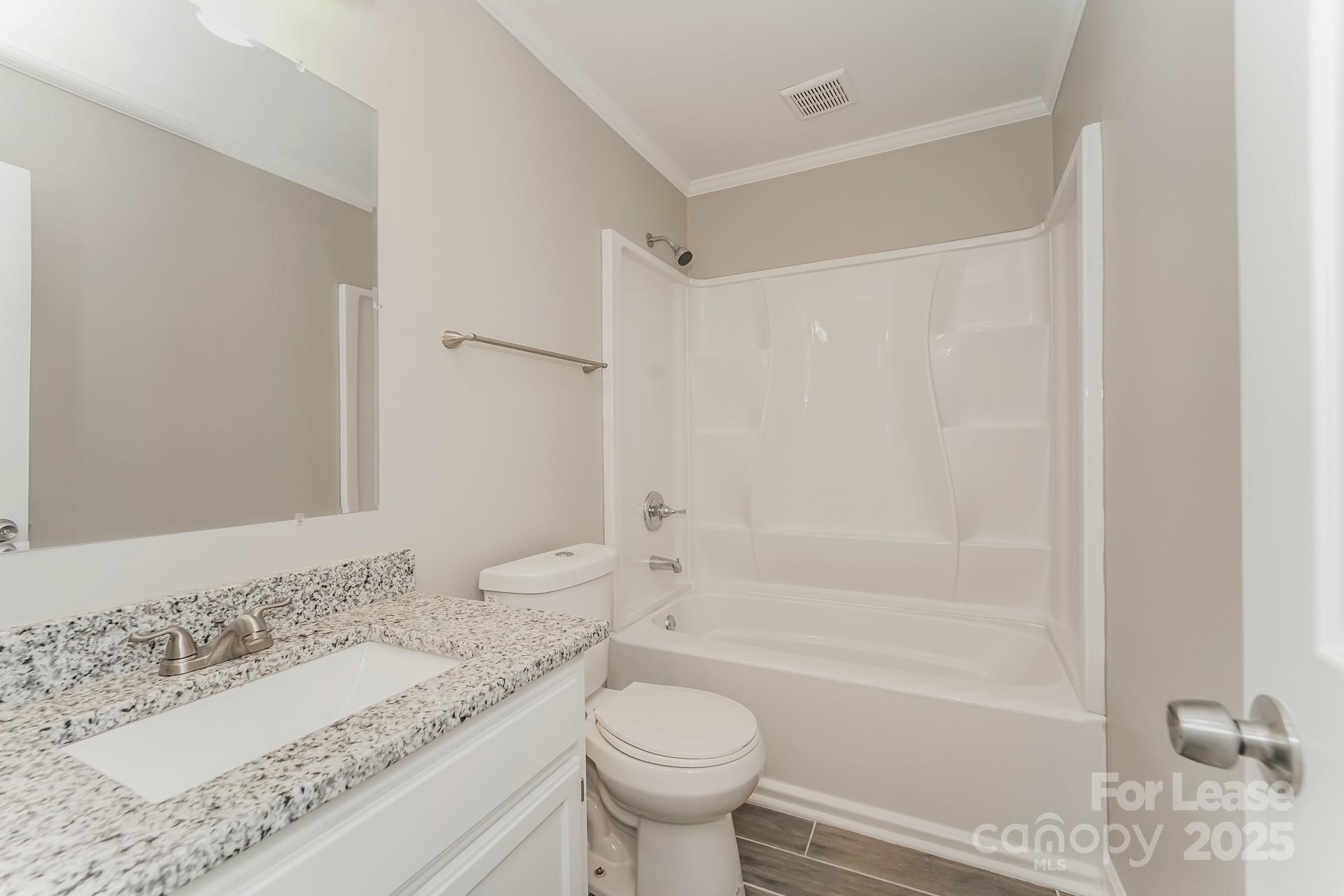 8301 Rocester Drive Charlotte, NC 28215 - Photo 14 of 16 a bathroom with a granite countertop sink toilet and shower