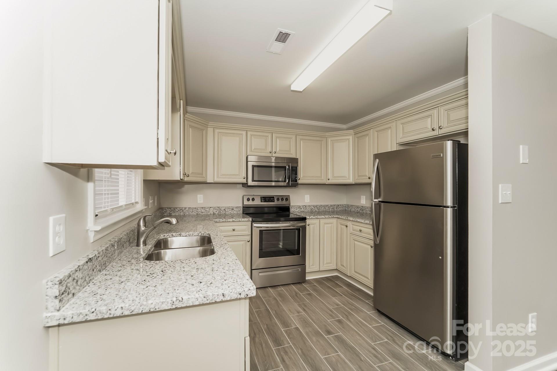 8301 Rocester Drive Charlotte, NC 28215 - Photo 7 of 16 a kitchen with a refrigerator sink and microwave