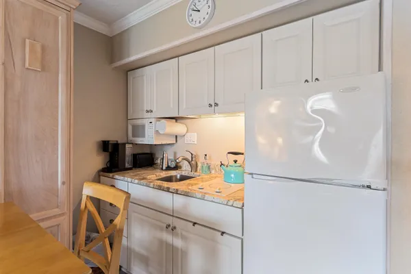 a kitchen with a refrigerator a stove a sink and cabinets