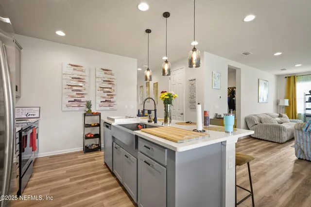 a kitchen that has a lot of cabinets and wooden floor