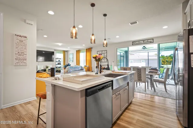 a kitchen with kitchen island a counter top space a sink appliances and a wooden floor