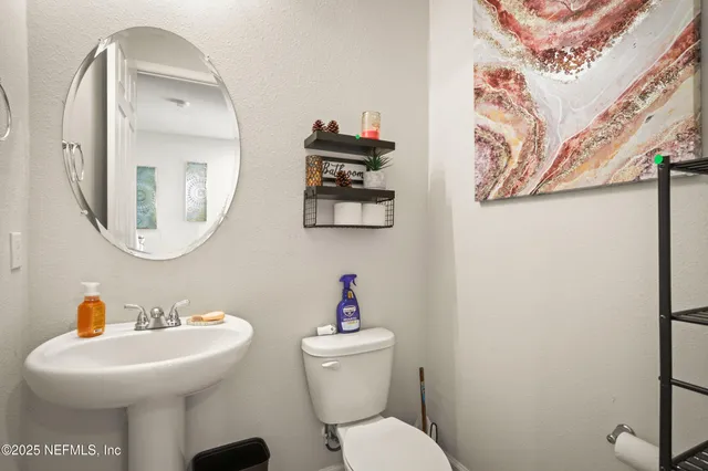 a bathroom with a toilet sink and mirror