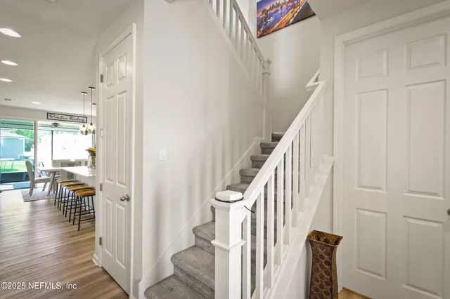 a view of a hallway with wooden floor and staircase