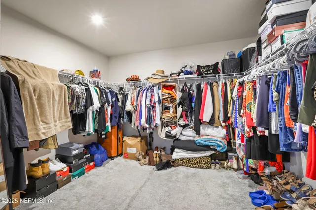 a view of walk in closet with clothes