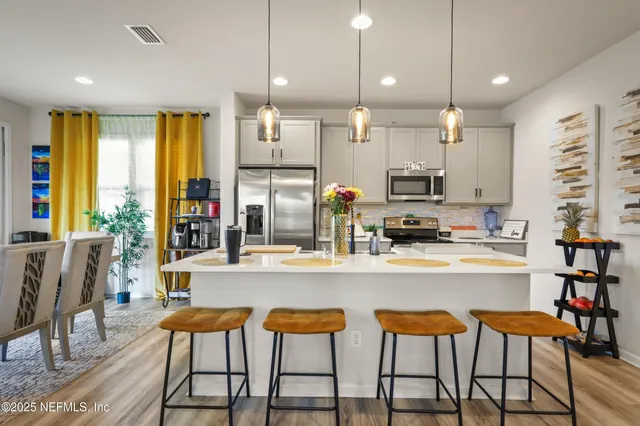 a kitchen with stainless steel appliances kitchen island granite top and refrigerator