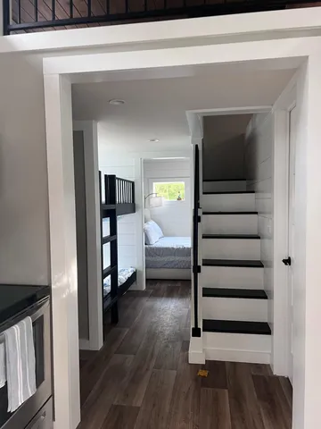 a kitchen with granite countertop a refrigerator oven a sink dishwasher and wooden cabinets with wooden floor