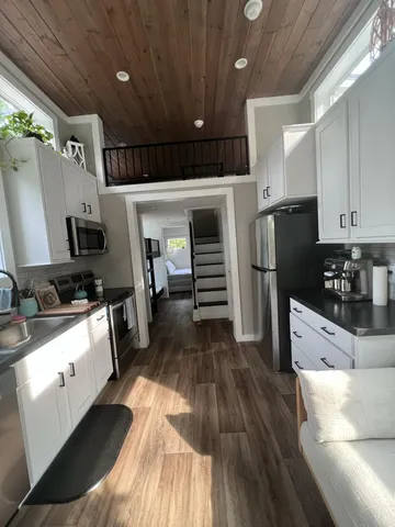 a living room with stainless steel appliances furniture and a large window