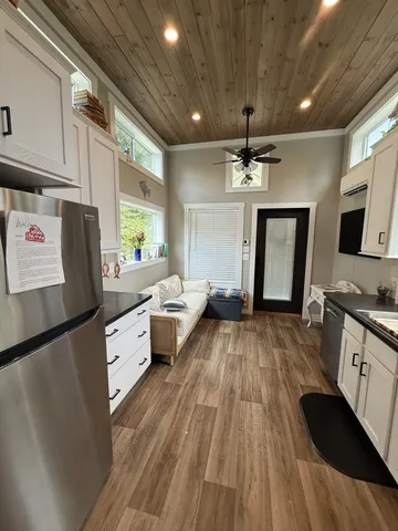 a open kitchen with stainless steel appliances granite countertop a sink dishwasher a refrigerator and wooden cabinets