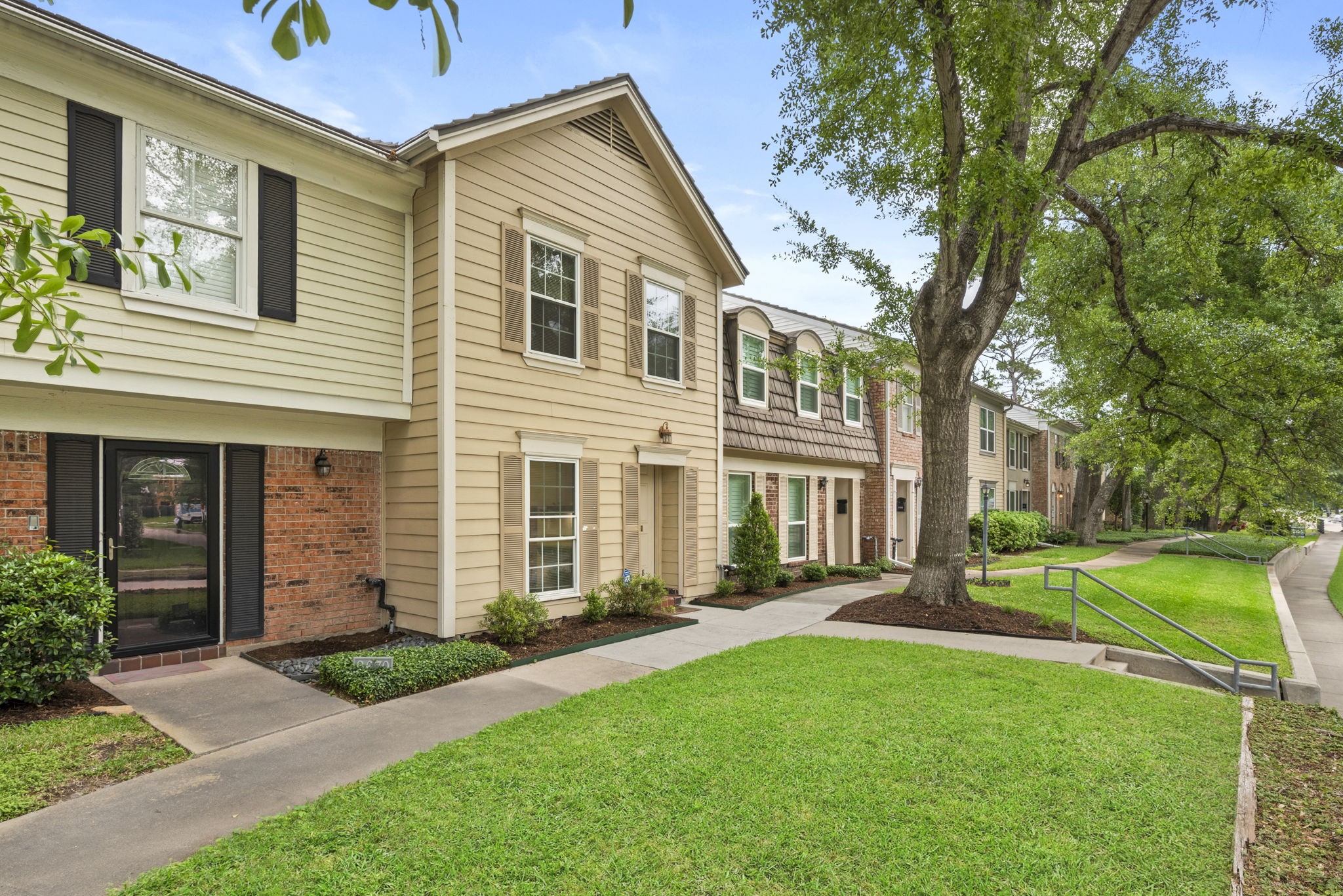9668 Westview Drive, Unit 2 Houston, TX 77055 - Photo 3 of 34 a front view of a house with a yard and trees
