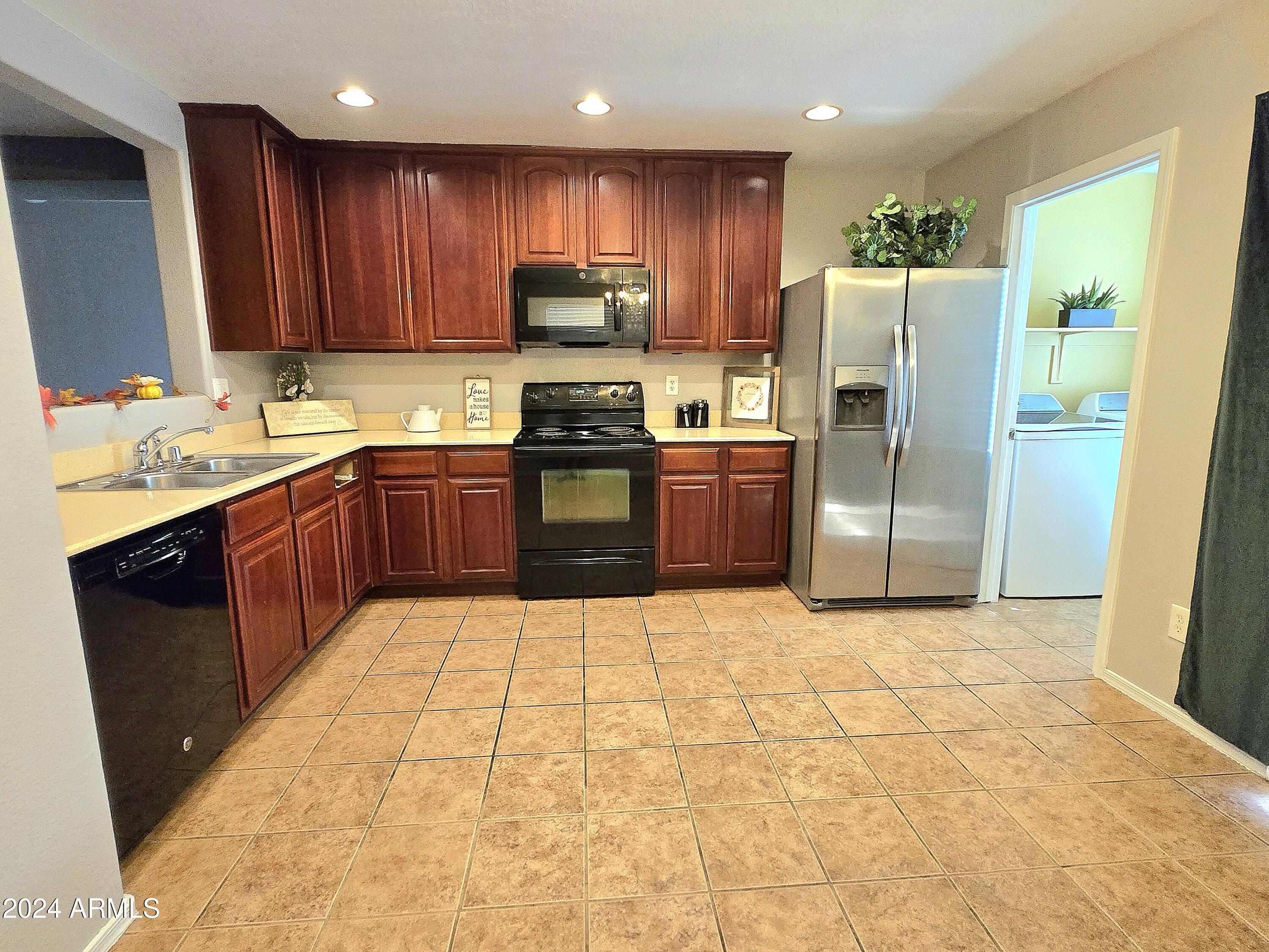 9365 West Eaton Road Phoenix, AZ 85037 - Photo 6 of 30 a kitchen with stainless steel appliances granite countertop a refrigerator stove top oven and sink