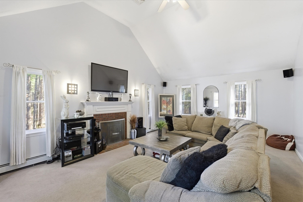 116 Meadow Street Carver, MA 02330 - Photo 14 of 42 a living room with furniture a flat screen tv and a fireplace