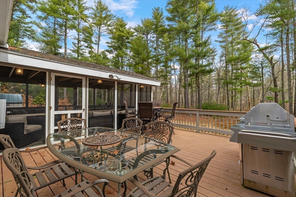 116 Meadow Street Carver, MA 02330 - Photo 35 of 42 a view of a patio with a table chairs and a floor to ceiling window