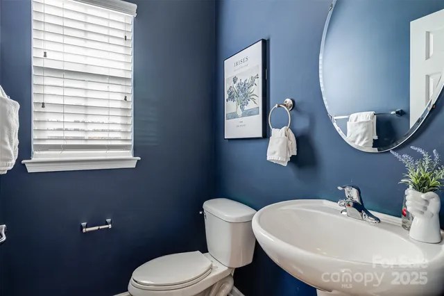 a bathroom with a toilet a sink and mirror