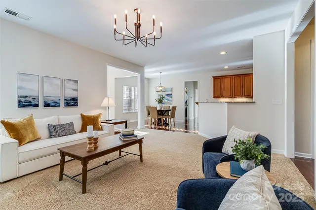 a living room with furniture and a chandelier