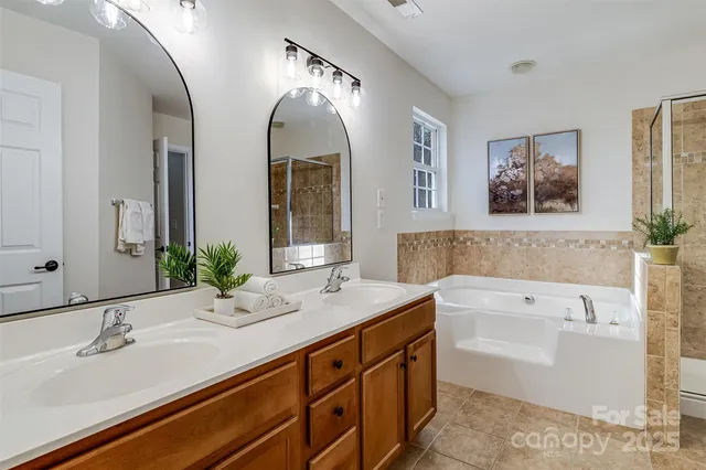 a spacious bathroom with a double vanity sink mirror and bathtub