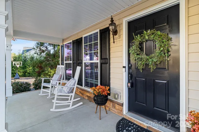 a view of a porch with chairs and potted plants