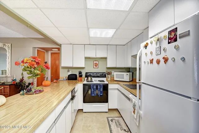 a kitchen with stainless steel appliances granite countertop a refrigerator a stove and a sink with cabinets