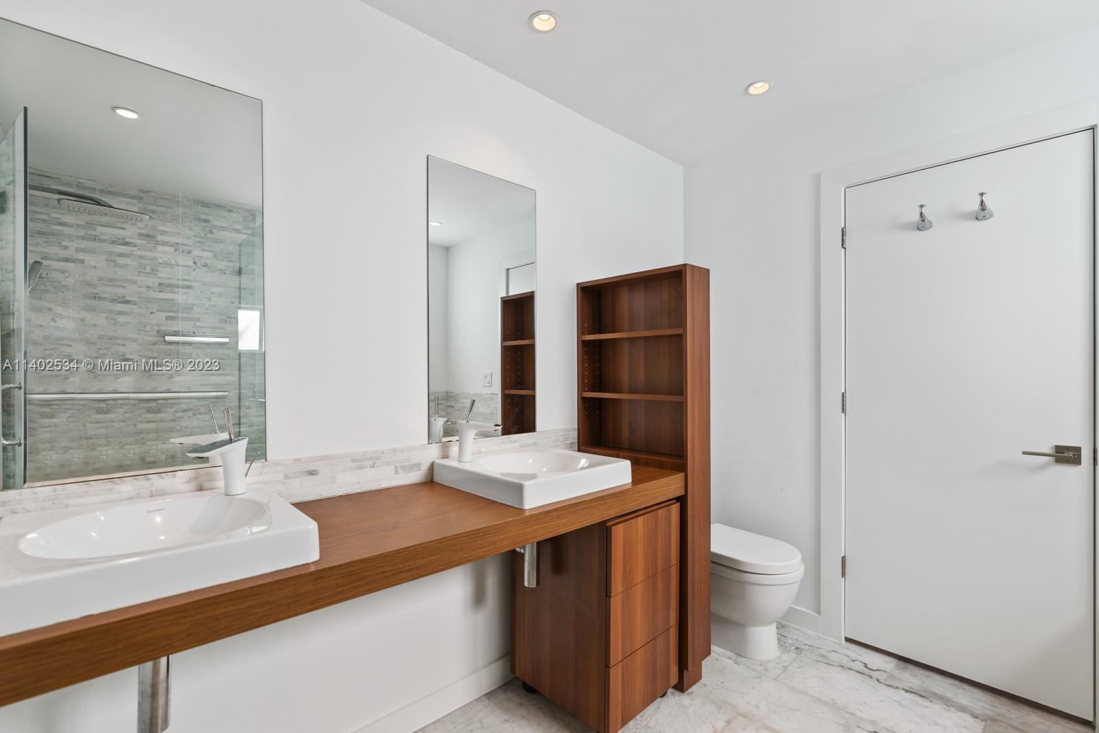 4741 Alton Road Miami Beach, FL 33140 - Photo 12 of 27 a bathroom with a sink a toilet and shower