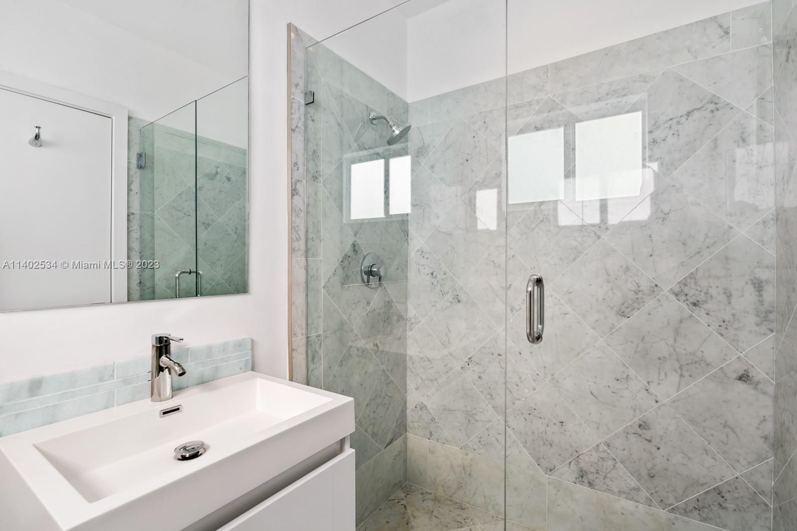 4741 Alton Road Miami Beach, FL 33140 - Photo 16 of 27 a bathroom with a sink mirror and shower
