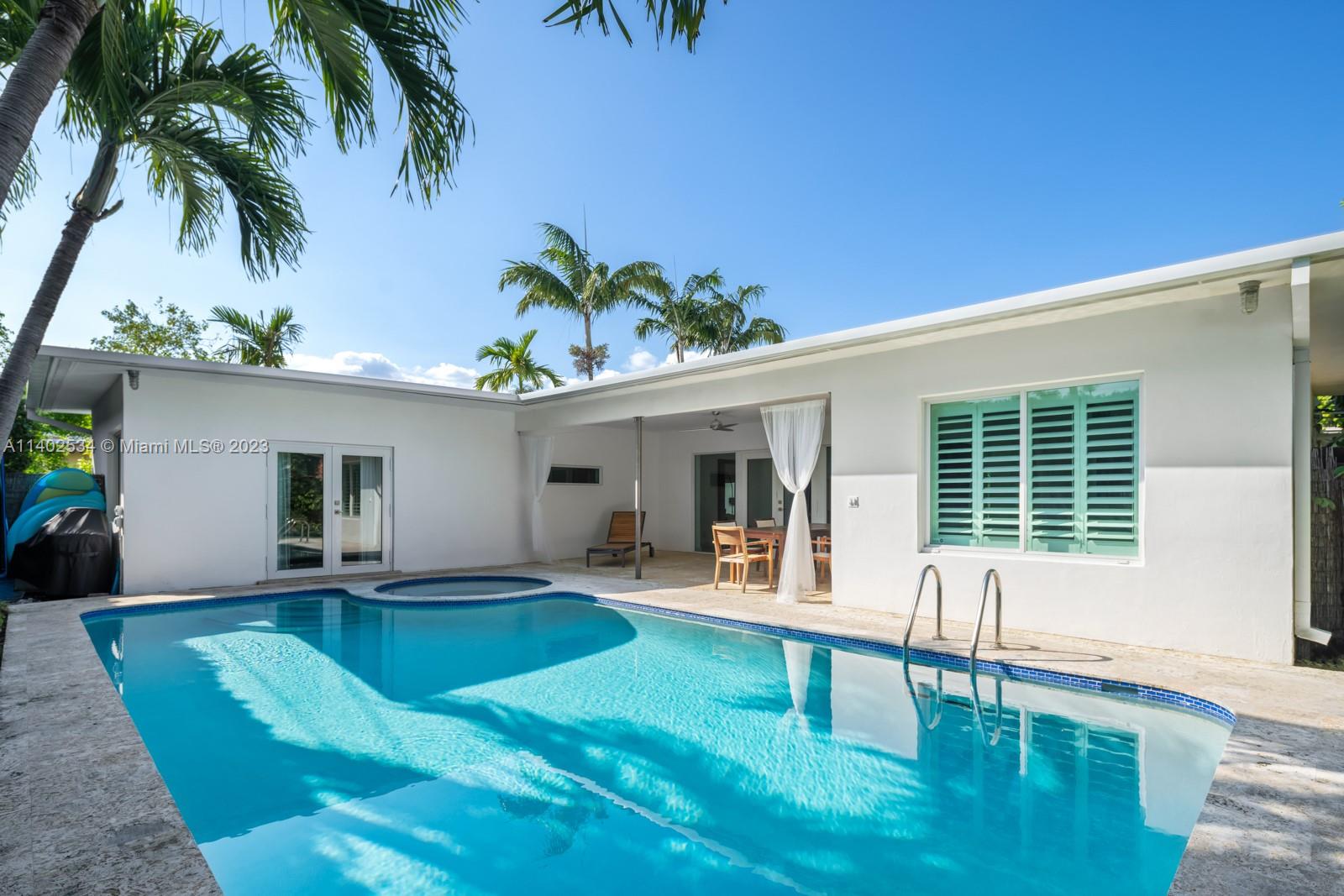 4741 Alton Road Miami Beach, FL 33140 - Photo 18 of 27 a view of a house with a swimming pool and sitting area