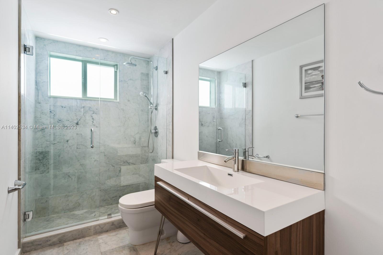 4741 Alton Road Miami Beach, FL 33140 - Photo 8 of 27 a bathroom with a sink a toilet and shower