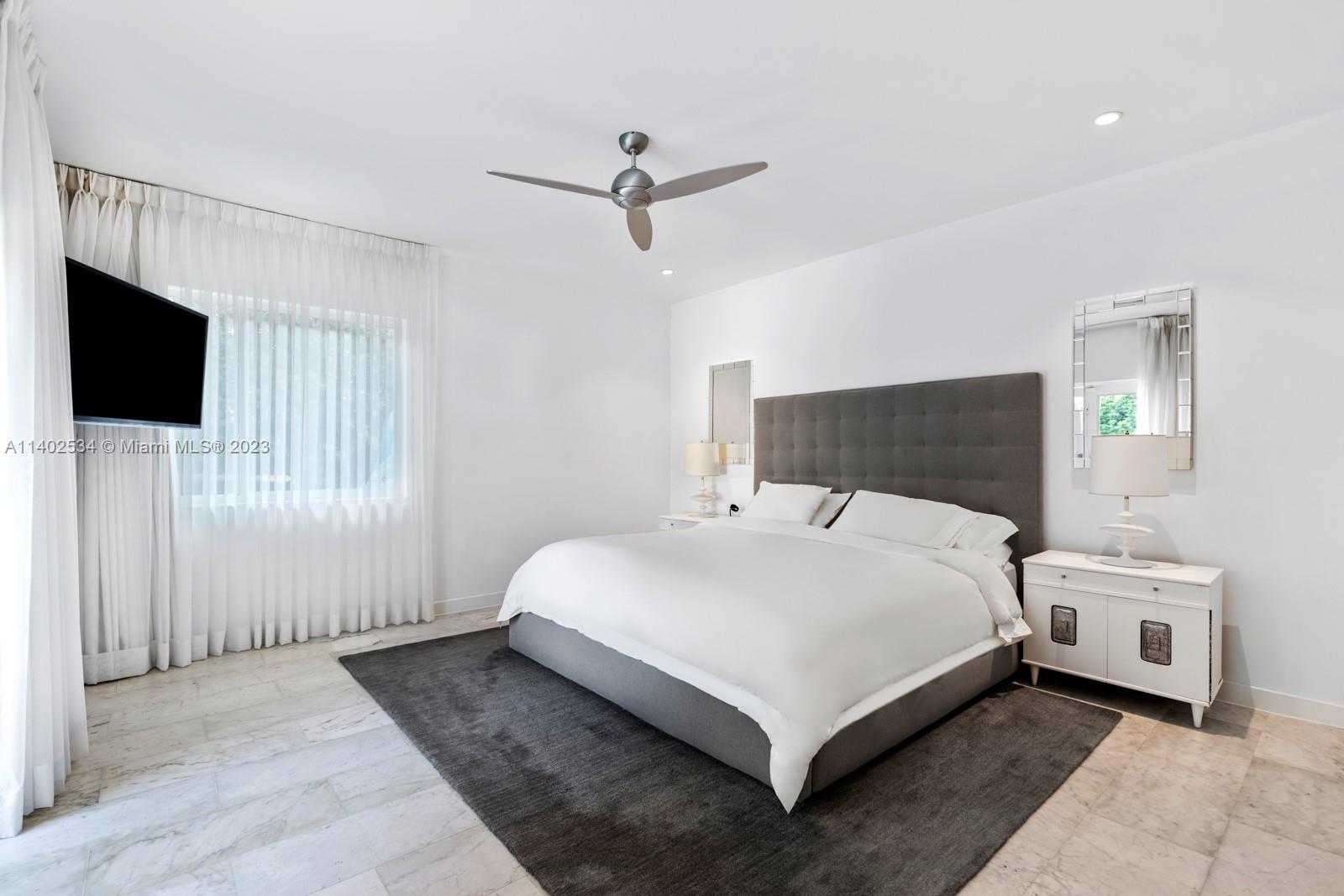 4741 Alton Road Miami Beach, FL 33140 - Photo 9 of 27 a bedroom with a bed and a flat screen tv