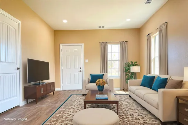 a living room with furniture a flat screen tv and a large window