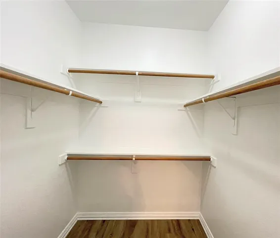 a view of walk in closet with empty racks