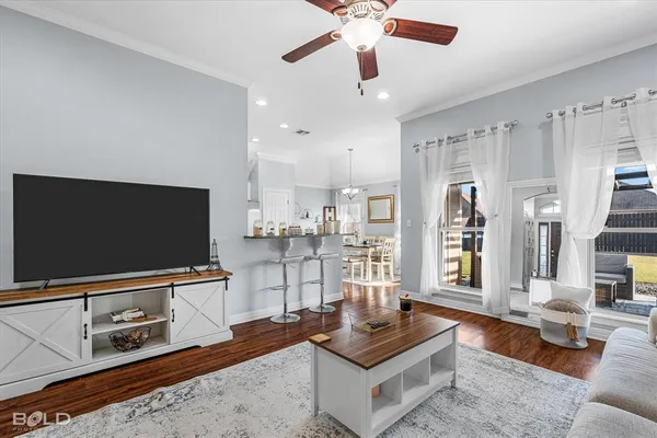 a living room with stainless steel appliances kitchen island granite countertop furniture and a flat screen tv
