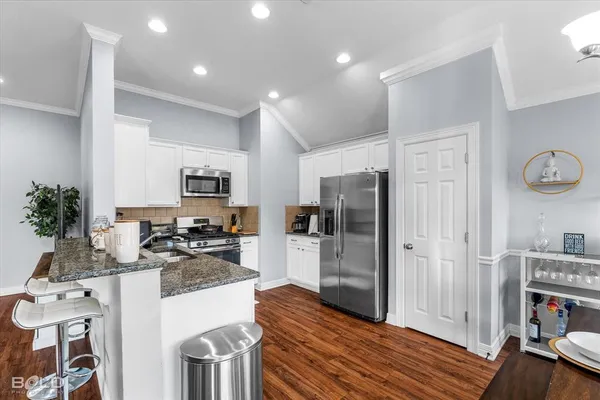 a kitchen with stainless steel appliances granite countertop a refrigerator a stove and a sink