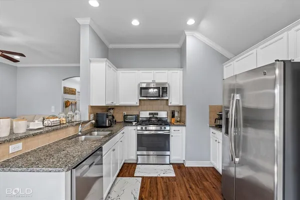 a kitchen with granite countertop a stove top oven and cabinets
