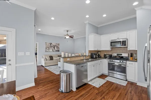 a spacious kitchen with stainless steel appliances granite countertop a sink and a counter space