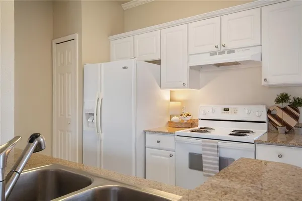 a kitchen with stainless steel appliances a refrigerator sink and cabinets