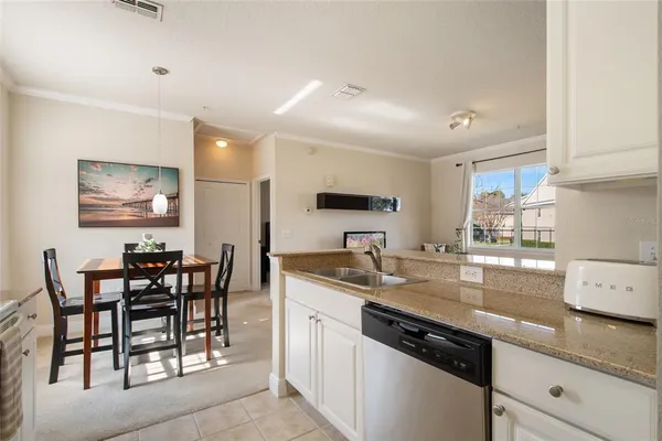 a kitchen with granite countertop sink table and chairs