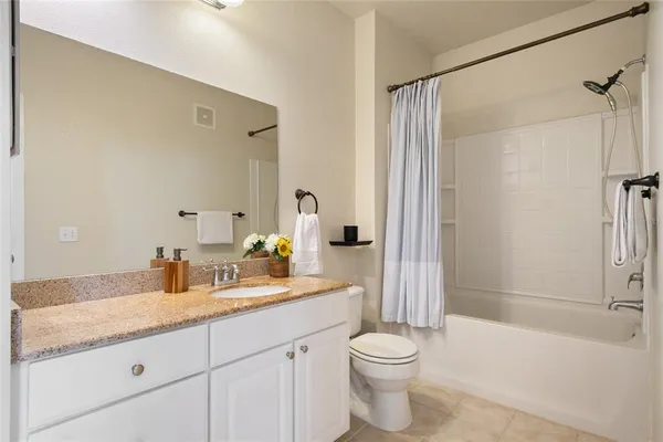 a bathroom with a granite countertop sink a toilet and shower